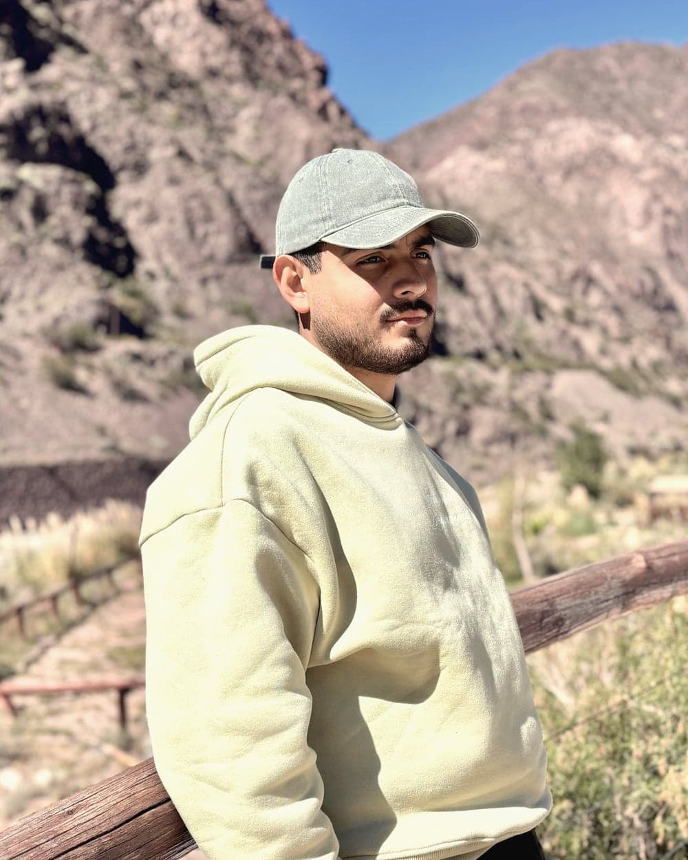 Fabio Escudero leaning on a wooden railing, with the Mendoza mountains behind him